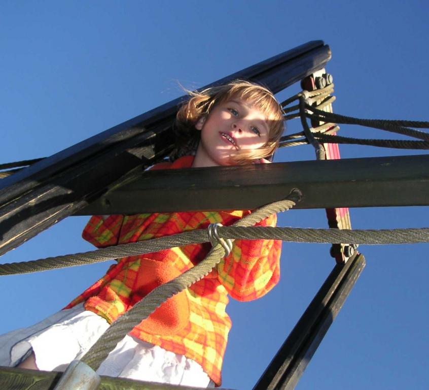 Girl with colourful jumper agains a bright blue sky